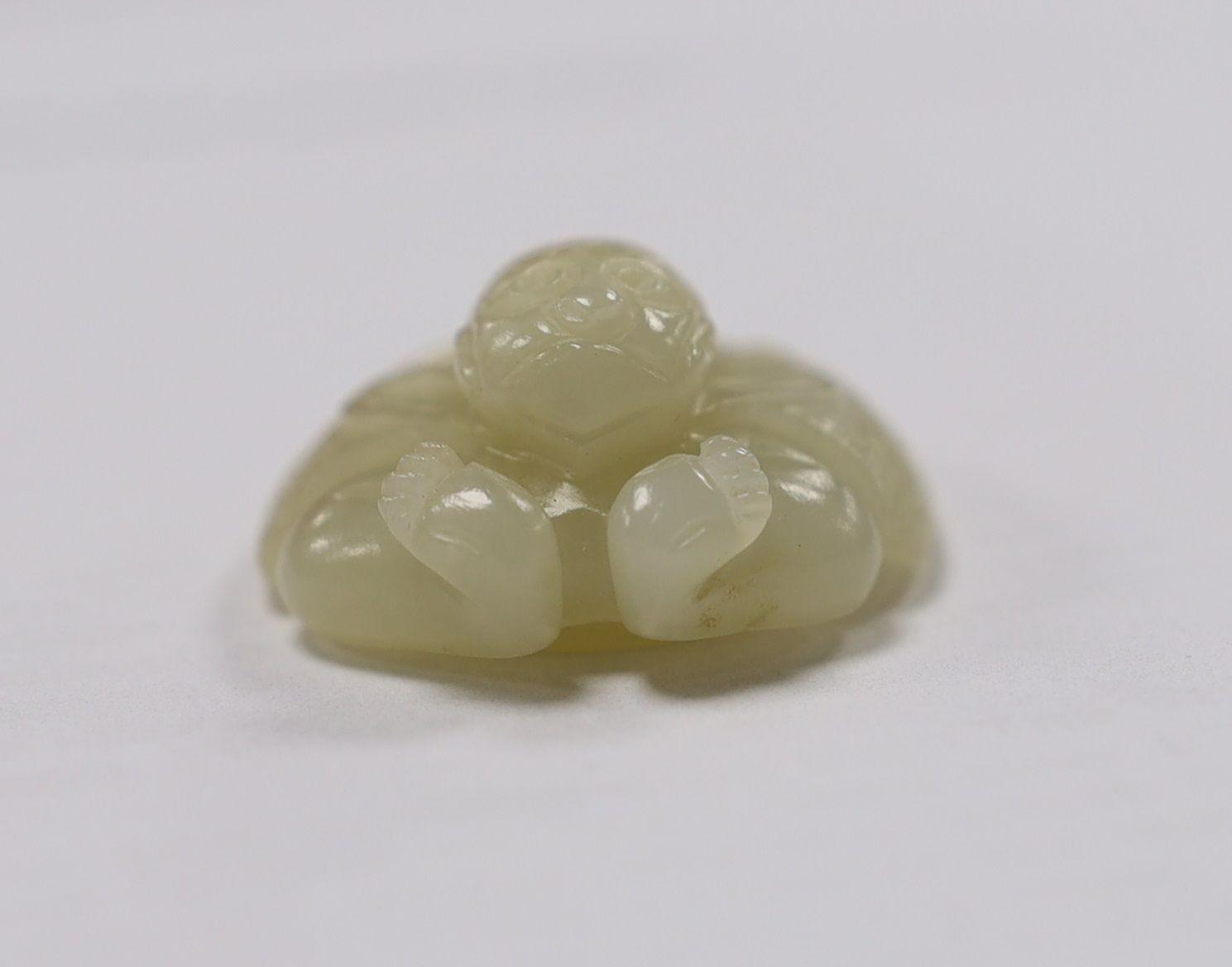 A Chinese pale celadon jade mount carved as a mythical half-man half-bird creature, 18th/19th century, 3.8cm high
